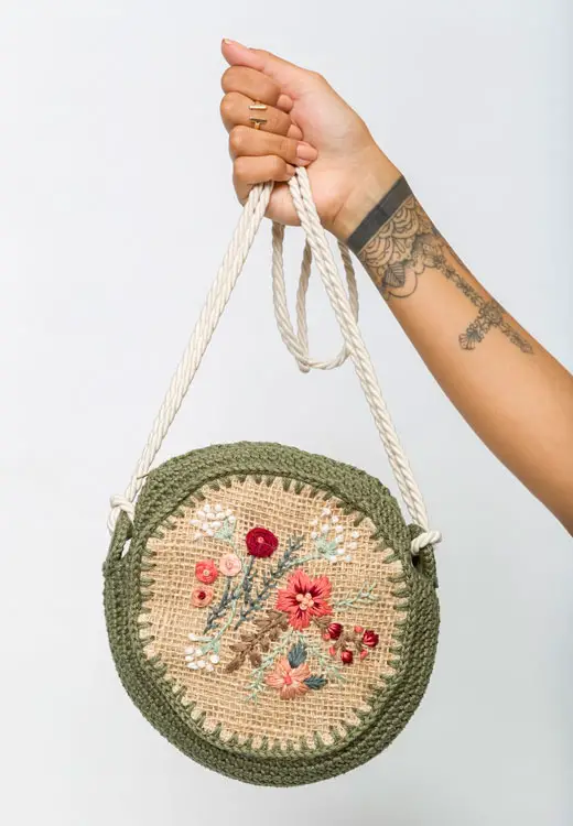 Bolsa em crochê redonda com bordado de flores
